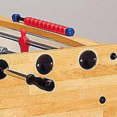 Detailansicht eines Tischkickers mit roten Spielfiguren und schwarzen Griffen auf einem Holztisch.