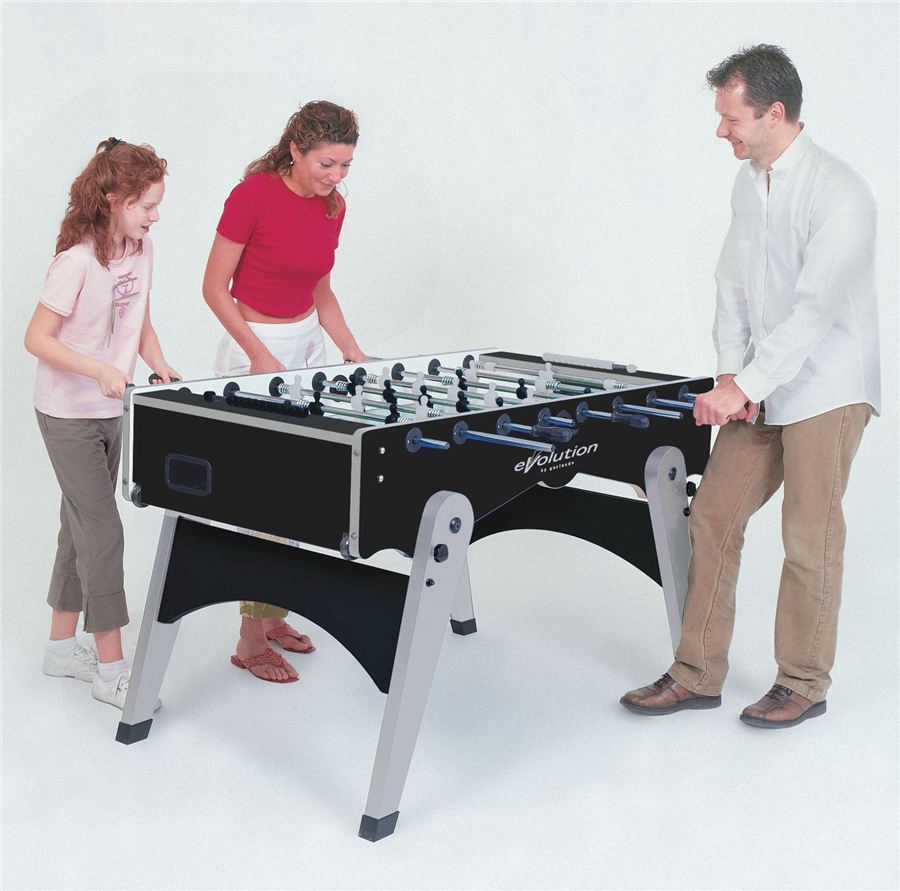 Drei Personen spielen gemeinsam Tischfußball an einem schwarzen Evolution-Kicker.