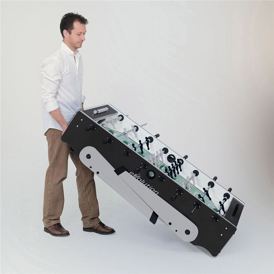 Ein Mann hebt einen schwarzen Kickertisch an einer Seite an, um ihn zu transportieren. Der Tisch ist modern gestaltet.