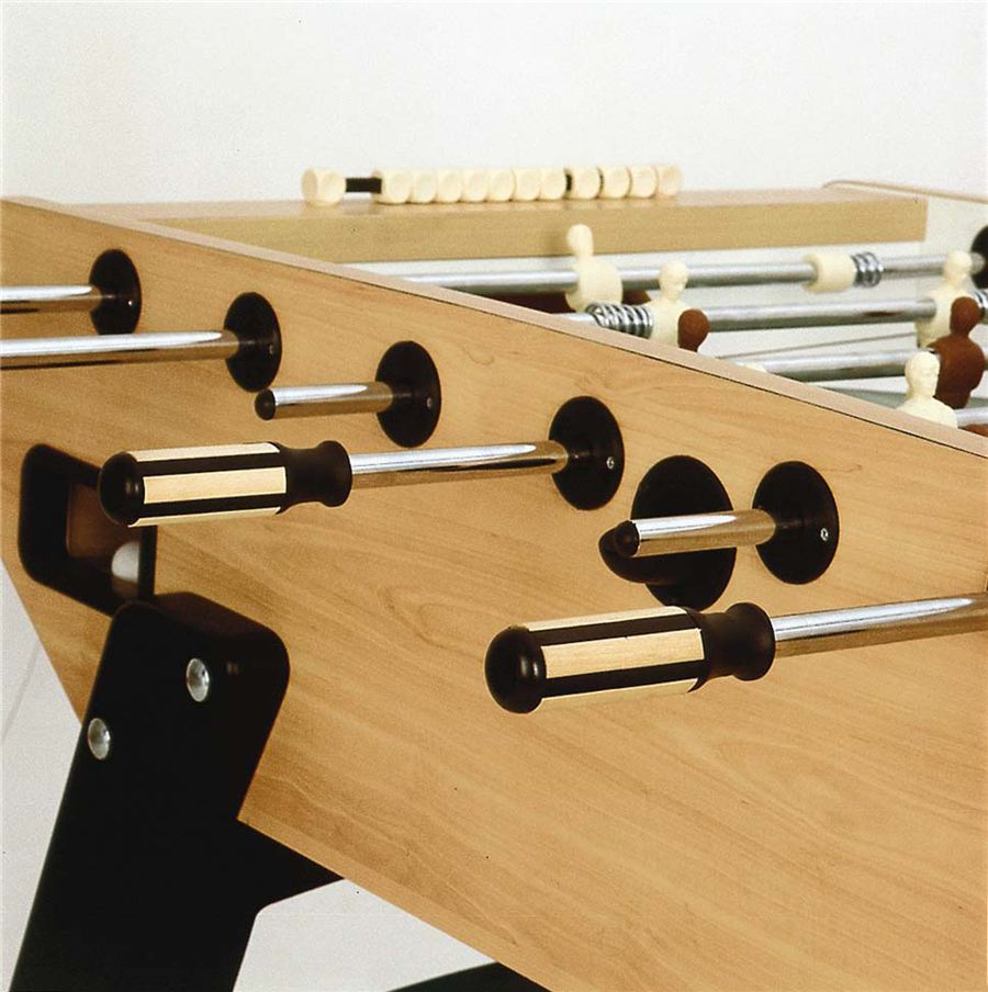 Nahaufnahme eines Kickertisches aus Holz mit schwarzen Griffen und Spielfiguren in Weiß und Braun auf Metallstangen.