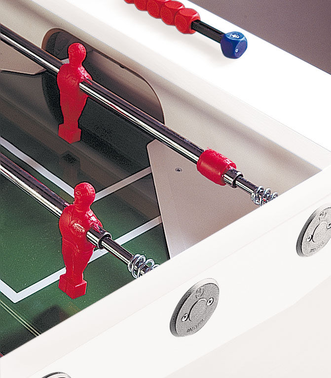 Detailaufnahme eines weißen Kickertischs mit roten Spielfiguren und Griffen, Metallstangen und grünem Spielfeld im Hintergrund.