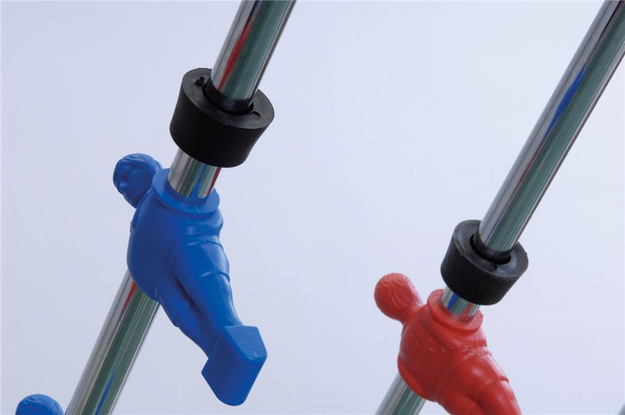 Zwei Tischfußballfiguren, eine blau und eine rot, sind an Metallstangen montiert und zeigen in entgegengesetzte Richtungen.