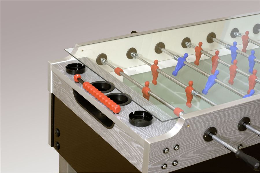 Tischfußballspiel mit roten und blauen Spielfiguren, rotem Griff und Getränkehaltern auf einer Holzoberfläche.