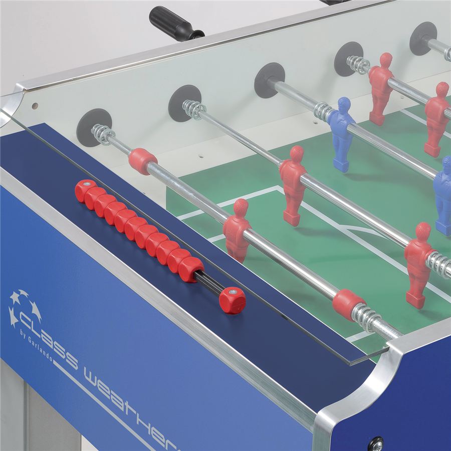 Tischfußballspiel mit roten und blauen Spielfiguren auf grünem Spielfeld, roter Griff an der Seite.