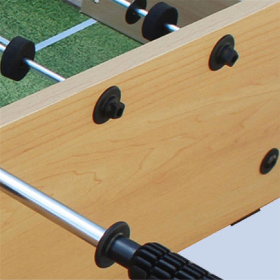 Detailaufnahme eines Kickertischs aus Holz mit Metallstangen und schwarzen Griffen, Spielfeld mit grünem Rasenmuster im Hintergrund.
