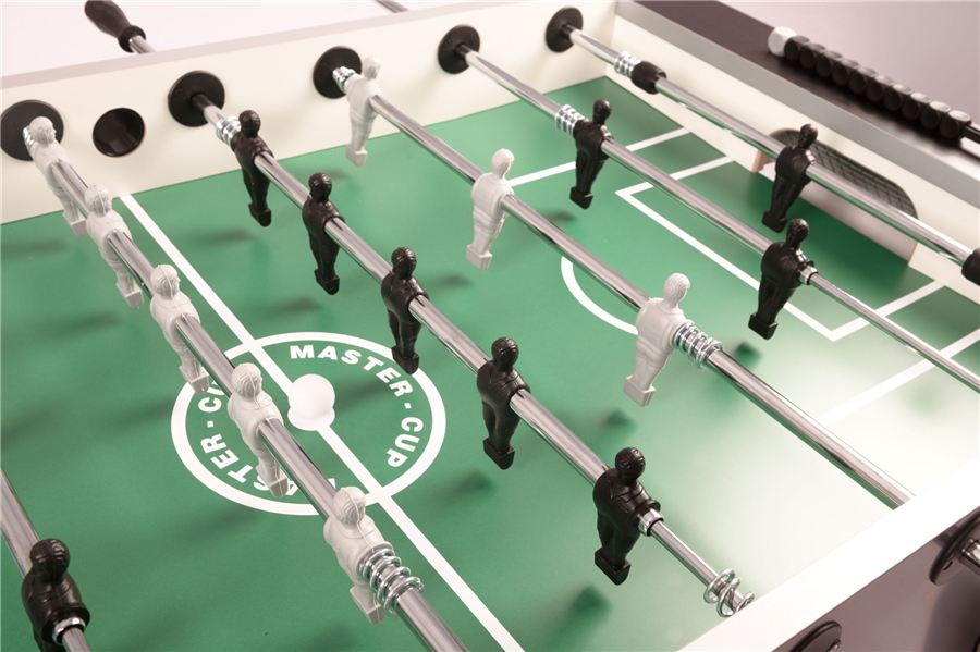 Tischkicker mit grünem Spielfeld, weißen und schwarzen Spielfiguren, Ball in der Mitte und Toranzeige am Spielfeldrand.