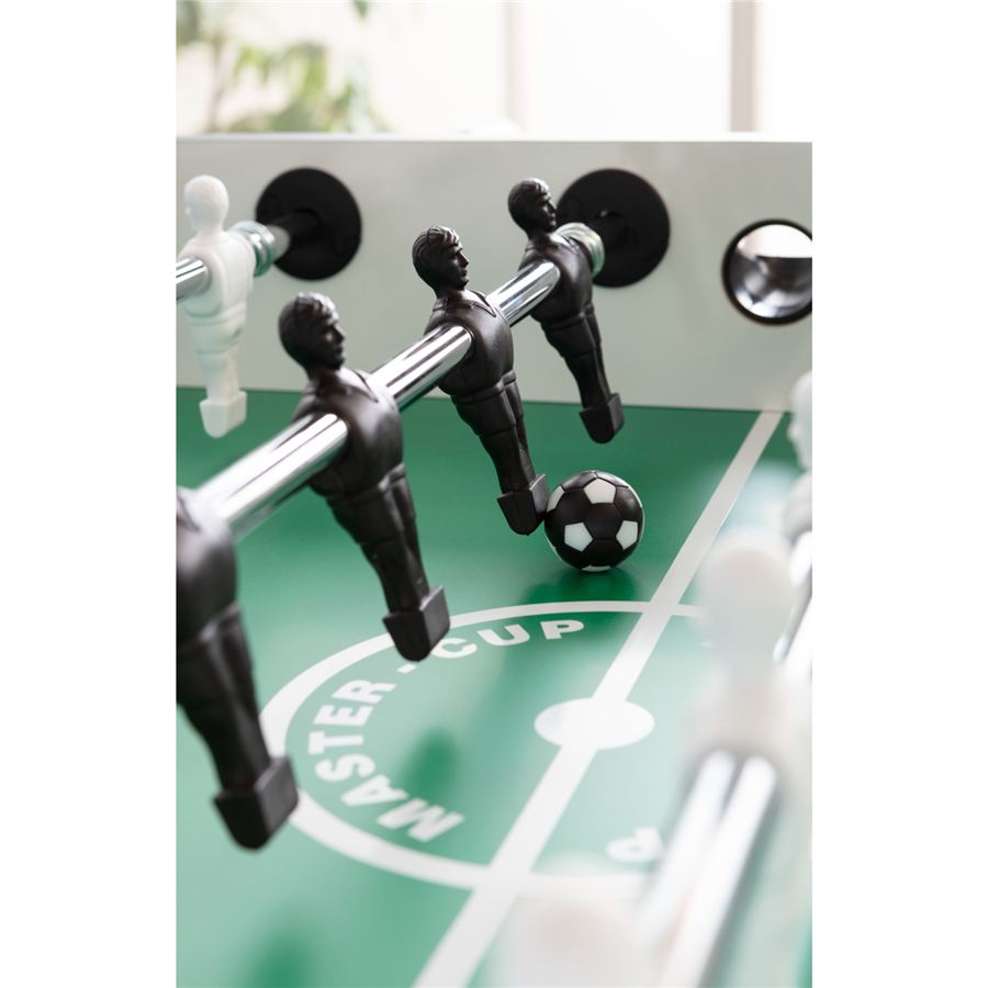 Detailaufnahme eines Kickertisches mit schwarzen und weißen Spielfiguren, Ball und Spielfeldaufschrift "MASTER CUP".
