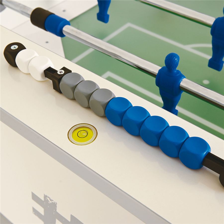 Nahaufnahme eines Kickertischs mit farbigen Torzählern in Weiß, Grau und Blau sowie blauen Spielfiguren auf grünem Spielfeld.